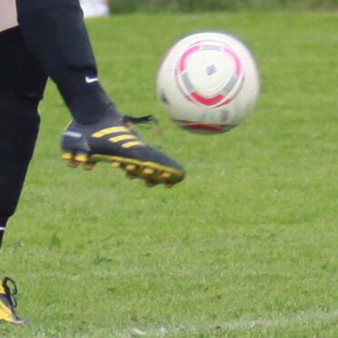 Fußballspieler beim Schuss auf dem Rasen